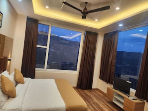 Ein Schlafzimmer mit Bett, Fernseher und Deckenventilator.