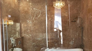 Un baño con una bañera independiente, un lavabo, un inodoro y una ducha.