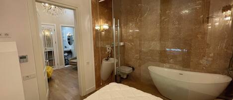 A modern bathroom with a freestanding bathtub, a glass shower enclosure, and a vanity with a mirror.