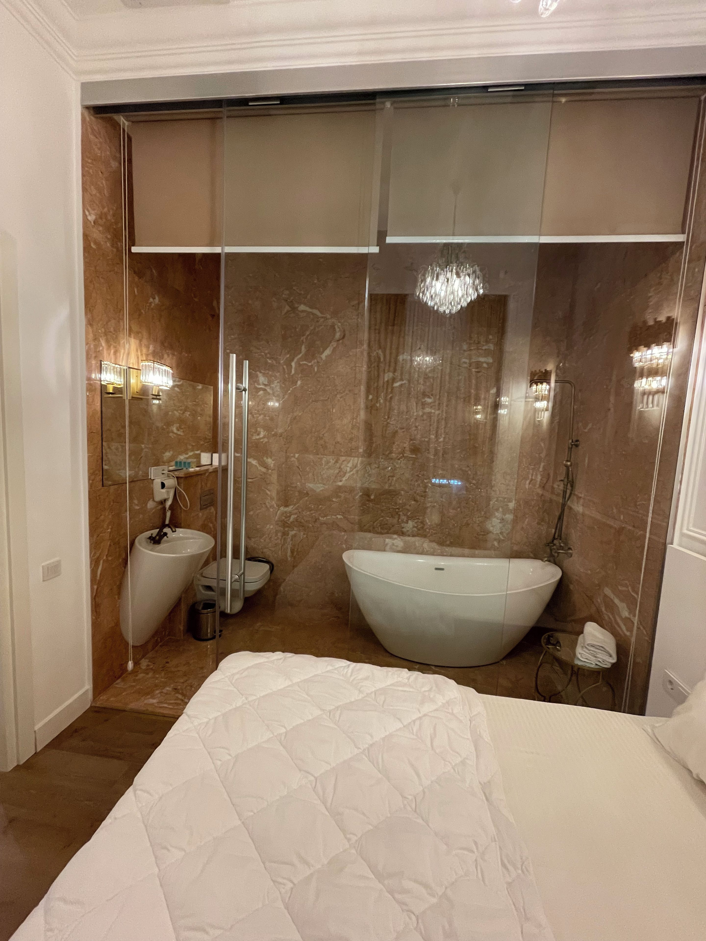 A modern bathroom with a large bathtub, a toilet, and a bidet.