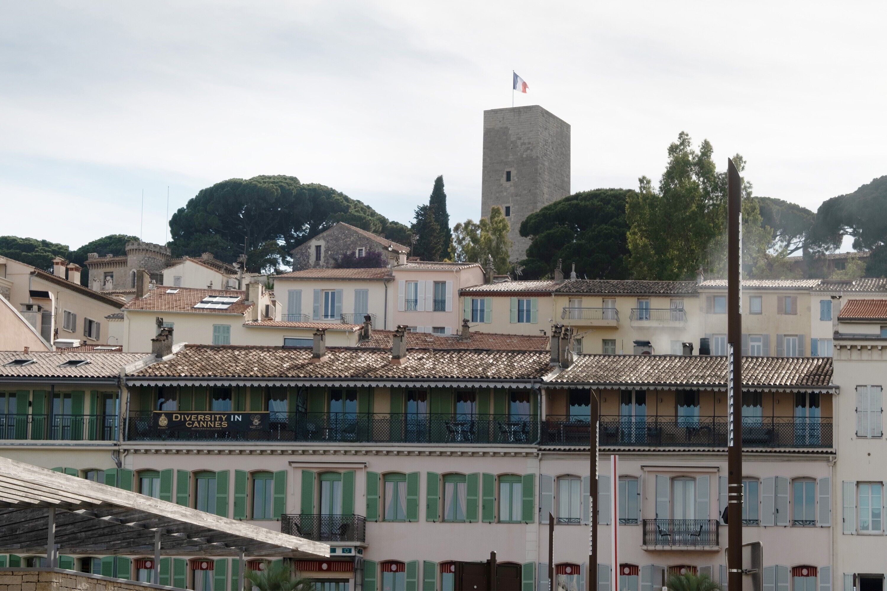 A historic town with traditional architecture, a prominent tower, and a building labeled 'Diversity in Cannes.'