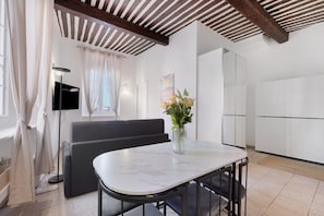 Een moderne keuken met witte kastjes, een marmeren aanrechtblad en een ingebouwde oven.