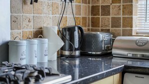 A kitchen with a coffee maker, a toaster, and a Hisense dishwasher. - Charming house with Garden in Aylesbury (Aylesbury)