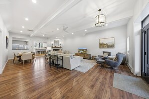 A spacious living area with a dining table, sofas, and a TV. - Lakefront | Hot Tub • Game Room • Sleeps 10 (Greenwood Lake)