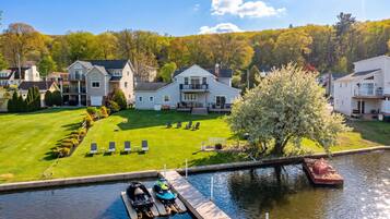 A residential area with a house, a dock with boats, and a small water body.