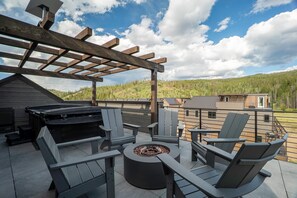 An outdoor patio with Adirondack chairs, a fire pit, and a pergola. - 12 Ramble Ln | Rooftop Hot Tub, Walk Downtown (Winter Park)