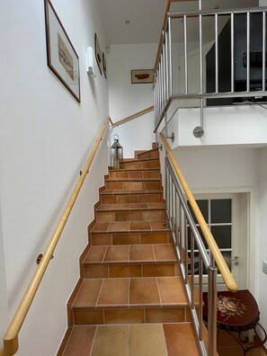 Eine Treppe mit hölzernen Geländern und einem Metallgeländer, das zu einer Tür führt.