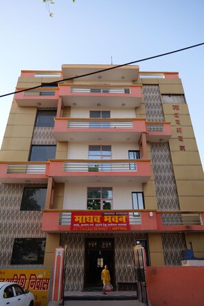 A multi-story building with a prominent signboard at the entrance. - Madhav Bhawan (Ayodhya)