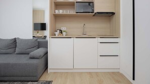 A compact kitchen with a microwave, cabinets, and a sink. - A comfortable studio near PGE Narodowy | A place to work (Warszawa)