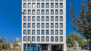 A modern building with a uniform facade, multiple windows, and a visible entrance. - A comfortable studio near PGE Narodowy | A place to work (Warszawa)