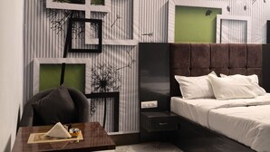A modern bedroom with a bed, a desk, and a chair. - Amrit Hotel & Resort (Thanagazi)