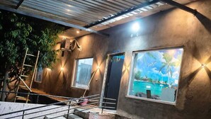 A construction site with a reception area, a staircase, and a large window with a tropical view. - Amrit Hotel & Resort (Thanagazi)