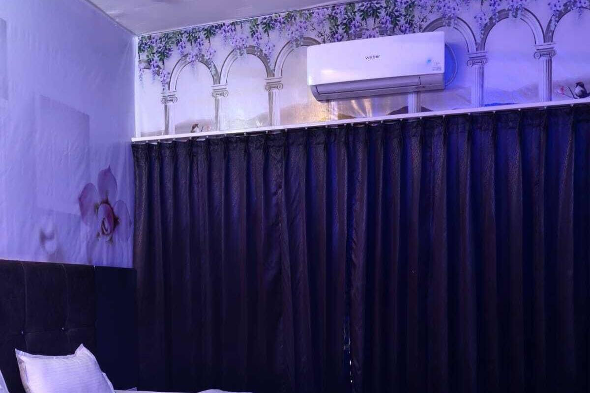 Habitación de hotel con cama, sofá, suelo de mármol y aire acondicionado.