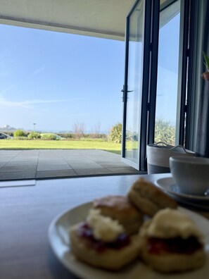 Ein Essbereich mit Blick ins Freie, ein Tisch mit einer Scones-Platte und einem Korb.