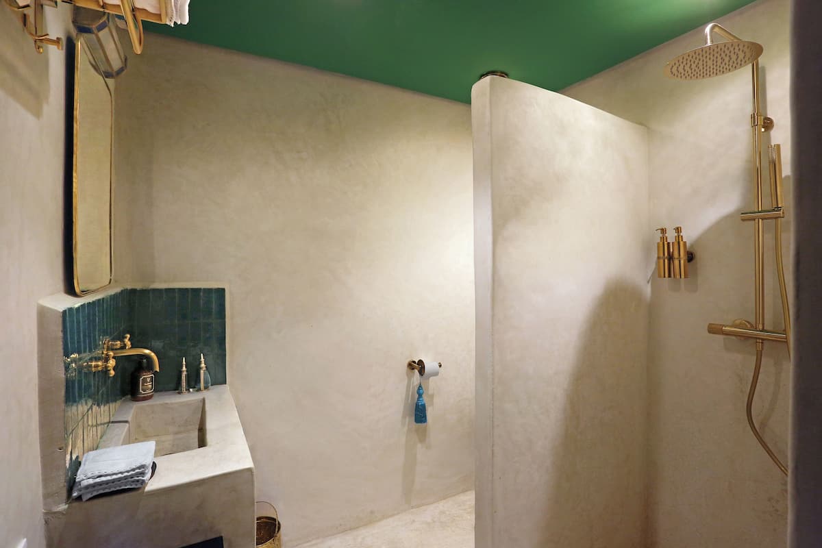 A bathroom with a shower, sink, and mirror.