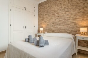 Ein Hotelzimmer mit einem Bett, einem Kleiderschrank, zwei Nachttischen mit Lampen und einer Holzvertäfelung.