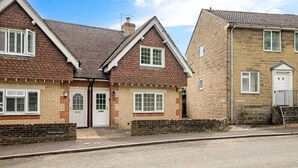 A row of terraced houses with brick and stone facades, white doors, and windows with shutters. - Comfortable Cottage with Decking in Castle Cary (Castle Cary)