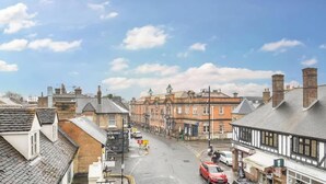 A street view with buildings, a clear sky, and a car on the road. - Charming 1BR Apartment | Parking Included (Windsor)