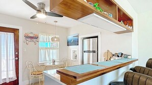 A modern kitchen with a built-in island, a ceiling fan, and a refrigerator.