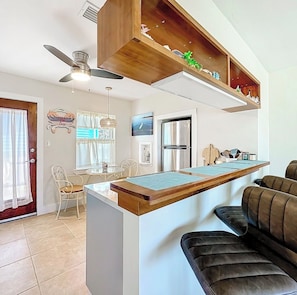 A modern kitchen with a built-in island, a ceiling fan, and a refrigerator.