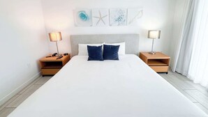 Ein großes Bett mit zwei Nachttischen, jeweils mit einer Lampe, in einem Raum mit schlichtem, klarem Design.