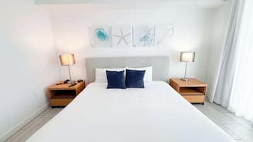 Ein großes Bett mit zwei Nachttischen, jeweils mit einer Lampe, in einem Raum mit schlichtem, klarem Design.