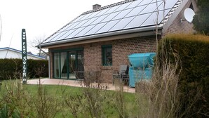 A house with a solar panel roof, a brick exterior, and a sign that reads 'WWW.FEWO SOLER'. - Holiday Home Jan Groen 8 (Wurster Nordseeküste)