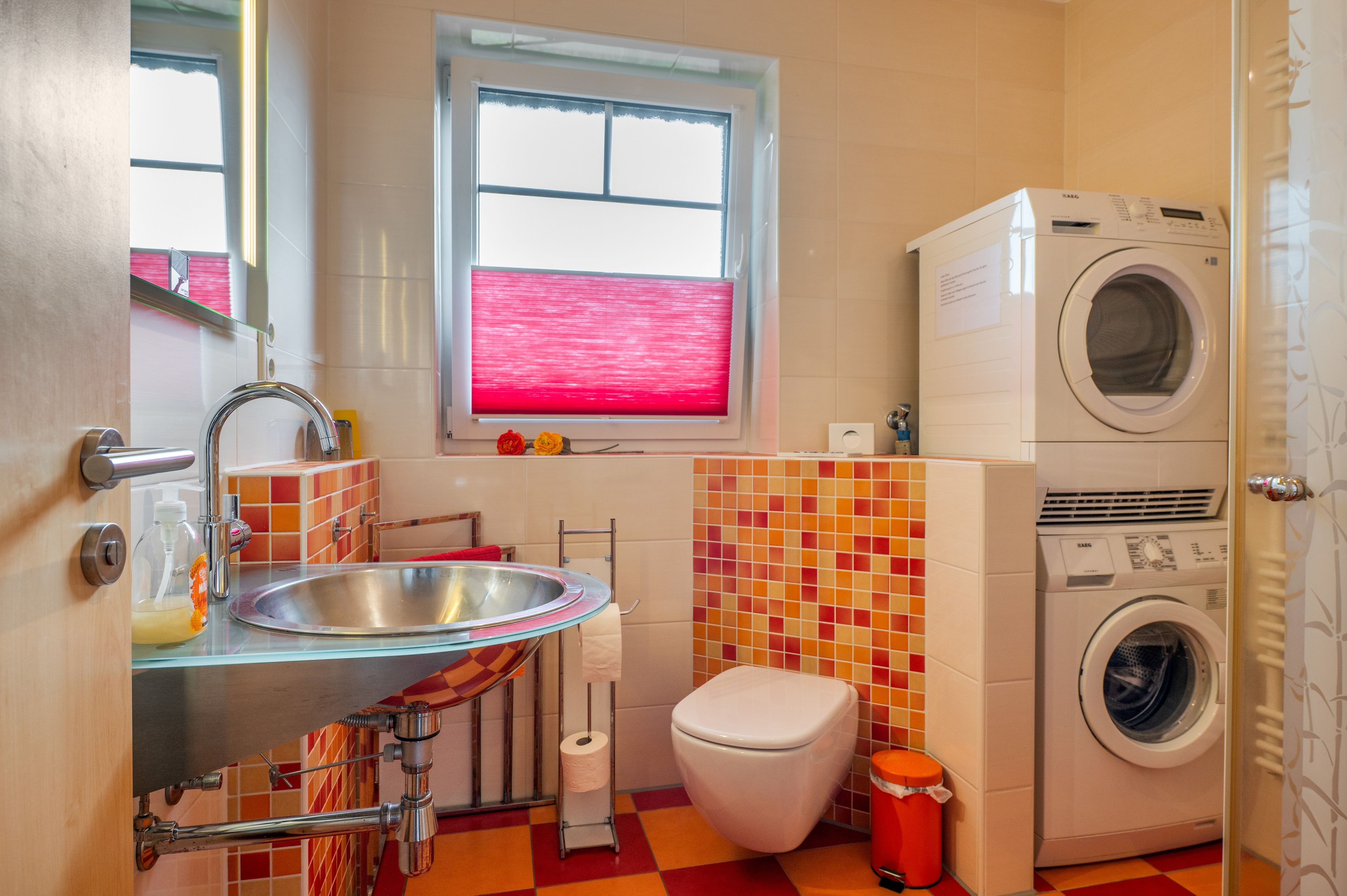 Ein kleines Badezimmer mit Waschbecken, Toilette und Waschmaschine.