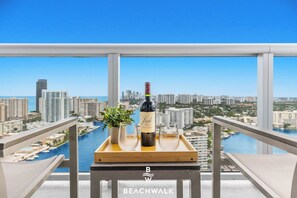 Ein Balkon mit Blick auf die Stadt, eine Weinflasche, ein Glas und ein Tablett.