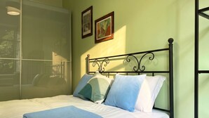 A bed with a metal frame, white bedding, and a blue throw blanket. - Casa Nicole - Fine Stay in Navigli District (Milan)
