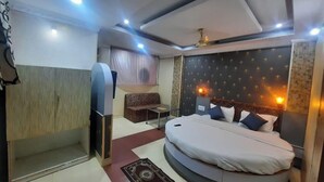 Un dormitorio con cama, sofá, una mesita y un armario.