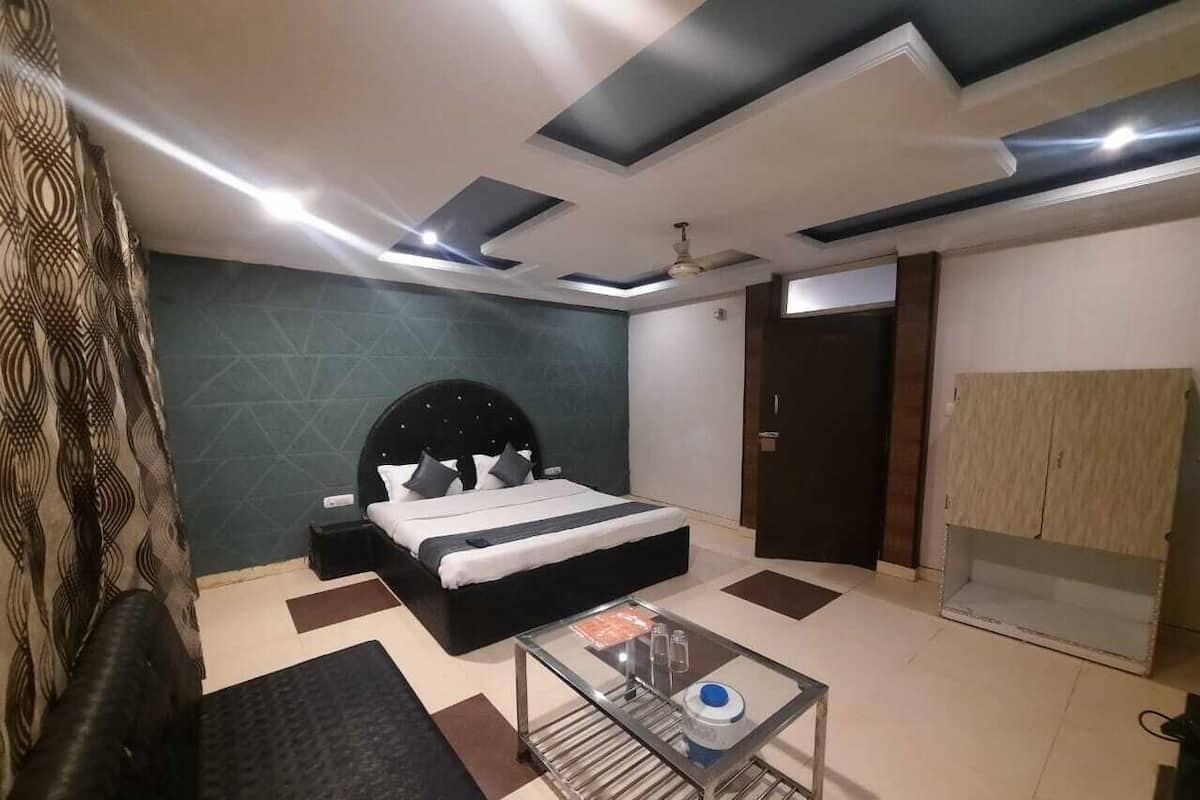 Un dormitorio moderno con cama, mesita de noche y una mesa de centro de vidrio.