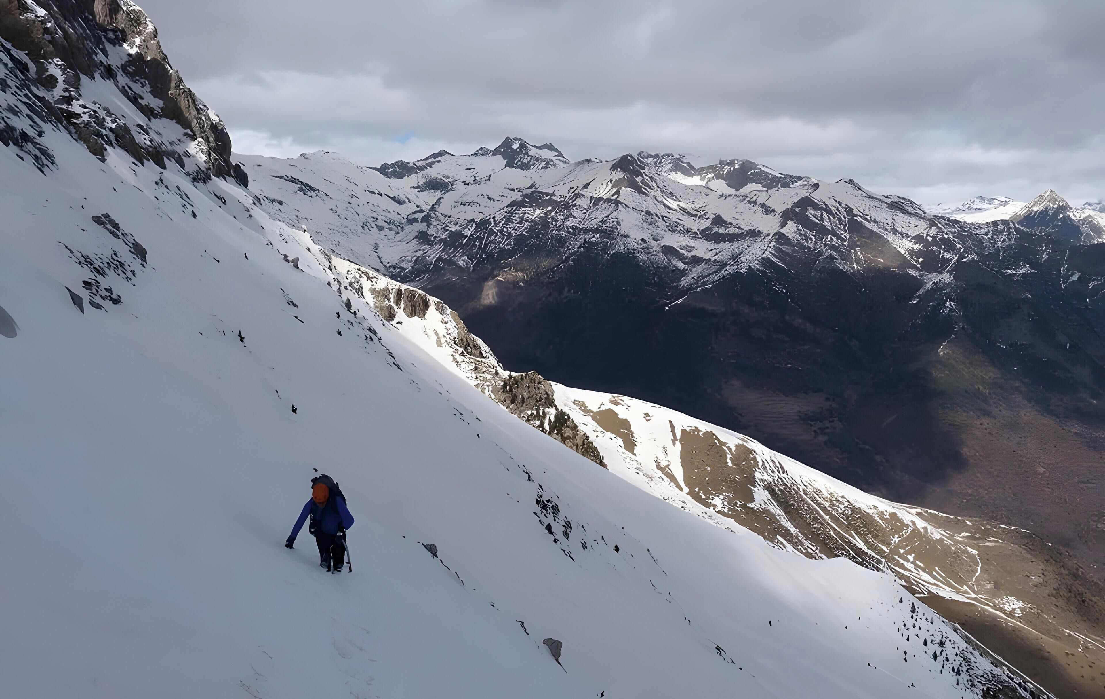 Pendiente nevada de una montaña con una persona caminando.