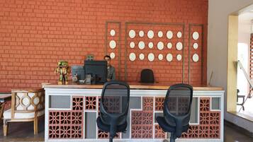 A reception desk with two chairs, a computer, and a decorative wall with circular patterns.