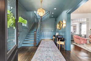 A staircase with blue walls and wooden steps leading to a landing. - Maison Barnard | Starland's Most Stunning Home + Private Pool, Event Space (Savannah)