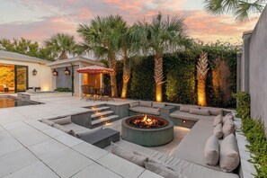 A landscaped outdoor area with a fire pit, seating, and a pool. - Maison Barnard | Starland's Most Stunning Home + Private Pool, Event Space (Savannah)
