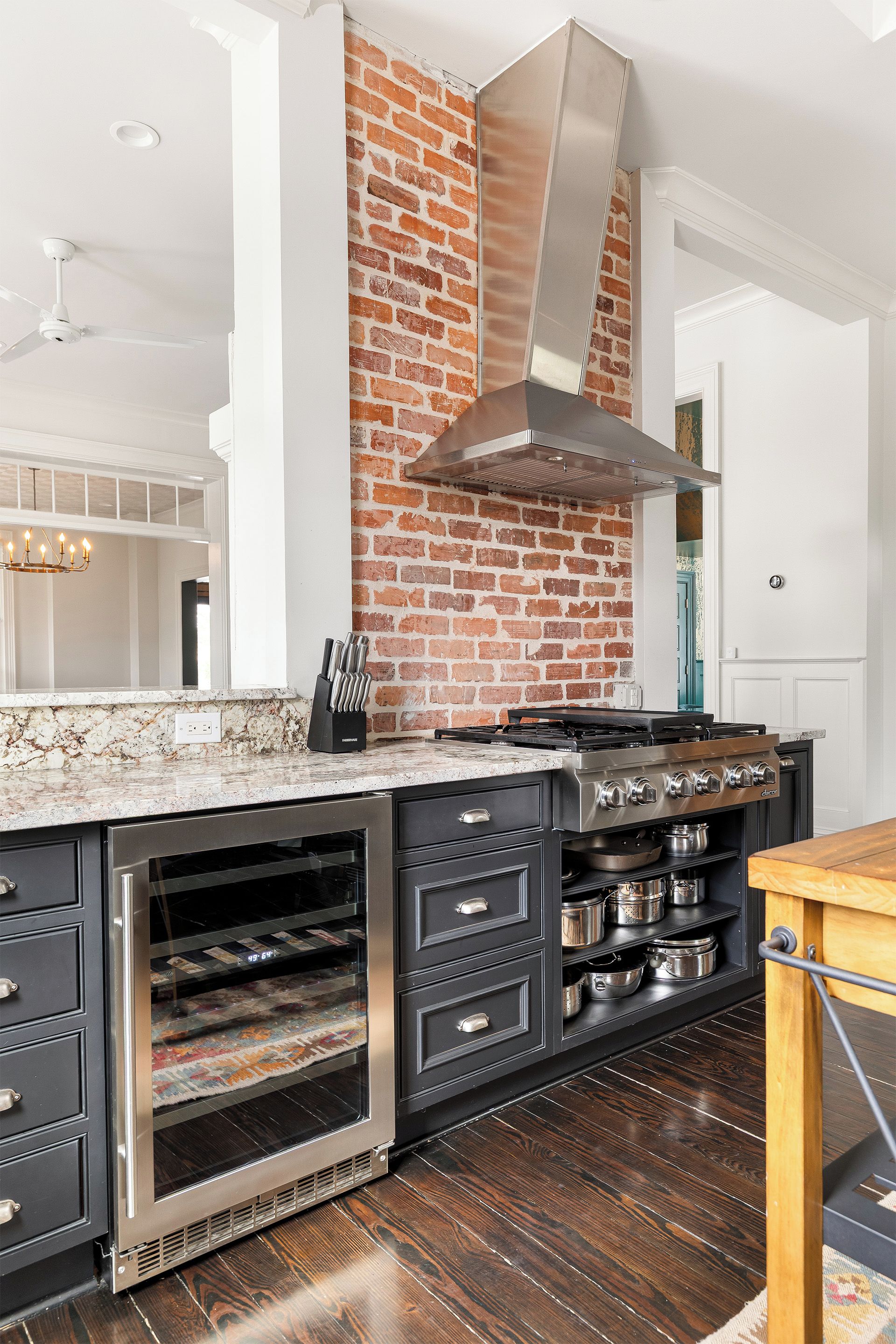 Una cocina moderna con una pared de ladrillo decorativa, electrodomésticos de acero inoxidable y un horno empotrado.