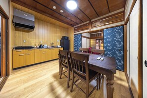 Cocina compacta con gabinetes de madera, microondas y refrigerador.