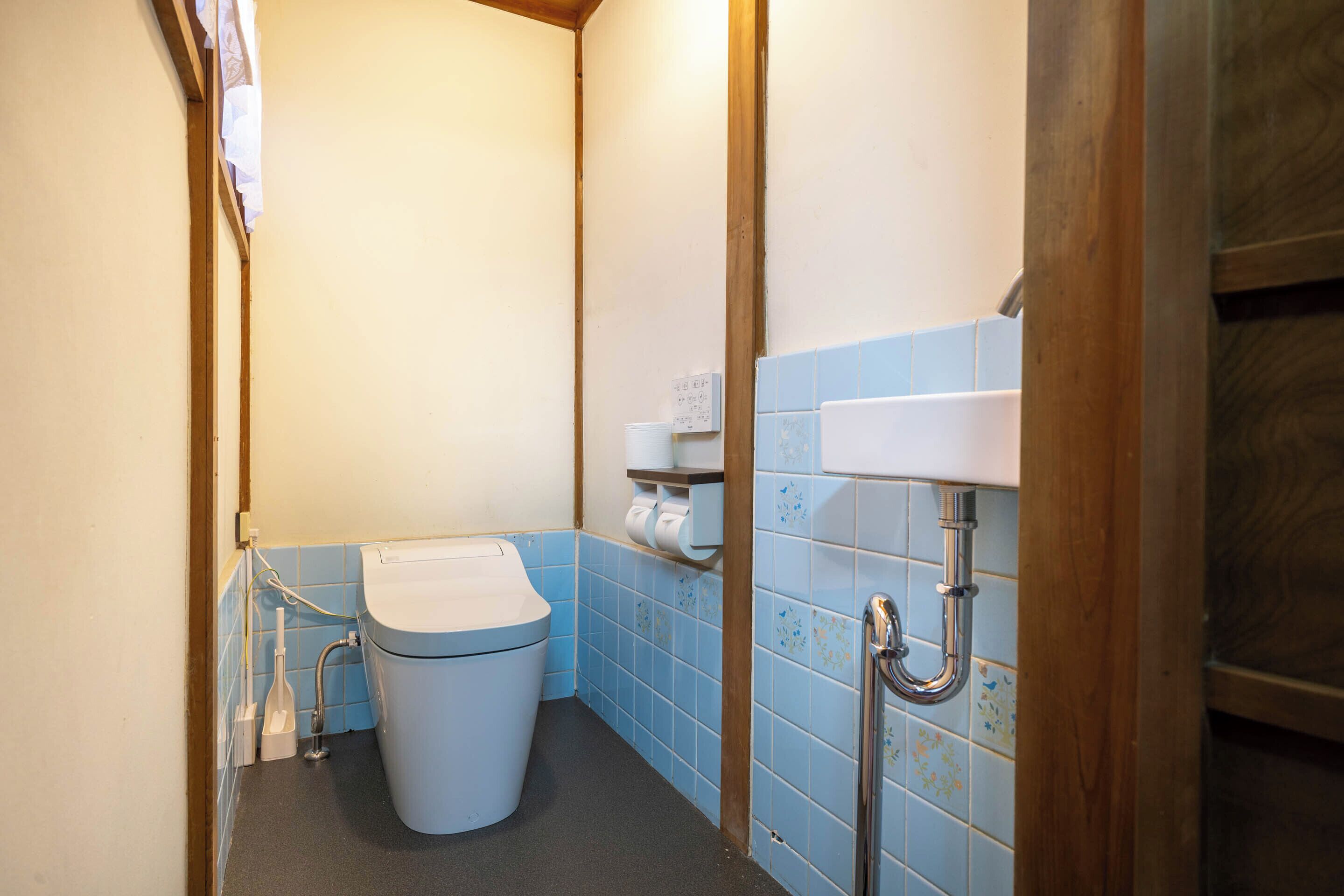 A small bathroom with a toilet, a sink, and a shower.