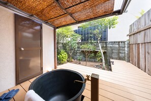A covered outdoor area with a barbecue grill, a wooden deck, and a bamboo roof. - Hakugetsu (Nara)