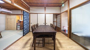 A traditional Japanese-style room with tatami flooring, a wooden table, and sliding doors. - Hakugetsu (Nara)