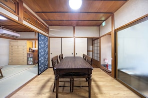 A traditional Japanese-style room with tatami flooring, a wooden table, and sliding doors. - Hakugetsu (Nara)