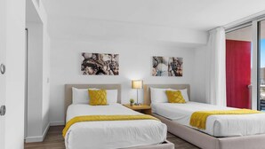 Ein Hotelzimmer mit zwei Betten, einem Nachttisch mit Lampe und Bildern an den Wänden.