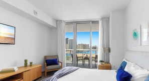A hotel room with a bed, a desk, a chair, a view of the city, and a balcony. - Panoramic 1BR · Bay View · Resort & Beach Access (Hallandale Beach)