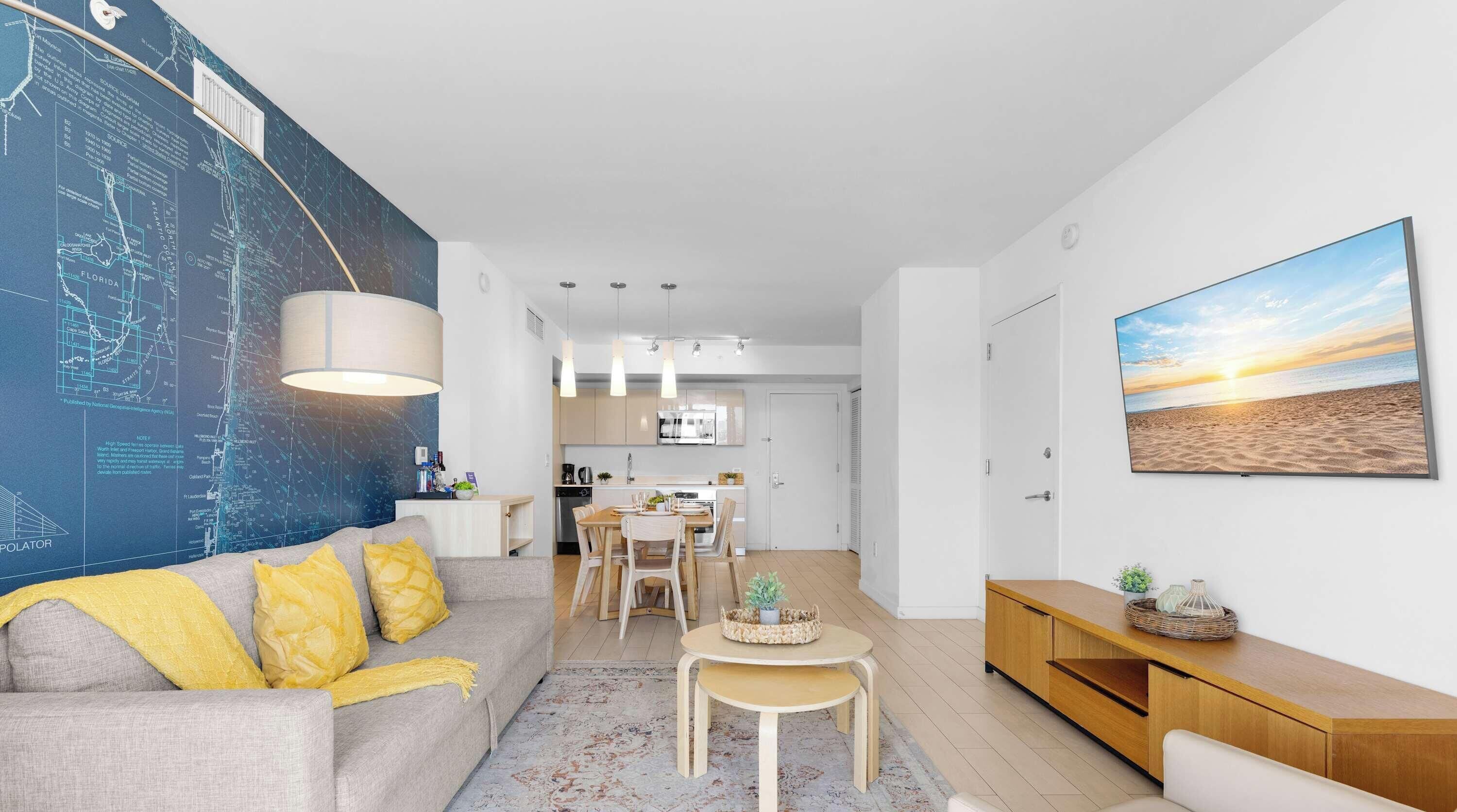Una sala de estar moderna con un mapa grande en la pared, un comedor y una cocina.