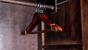 A wooden hanger with a metal hook against a wall. - TAM COC HA ANH HOTEL (Nam Hoa Lu)