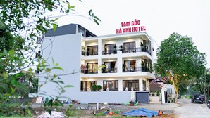 A multi-story hotel with balconies, a sign reading 'TAM COC HA ANH HOTEL,' and a tree in the foreground. - TAM COC HA ANH HOTEL (Nam Hoa Lu)