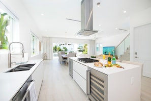 A modern kitchen with a central island, stainless steel appliances, and a dining area with a view.