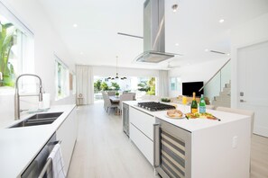 The kitchen is equipped with top of the line appliances including an ice maker and wine fridge. - Oceans 9, Villa 8: Lazy River Pool, Sunken BBQ Lounge + Designer Interiors in West Bay (Grand Cayman)