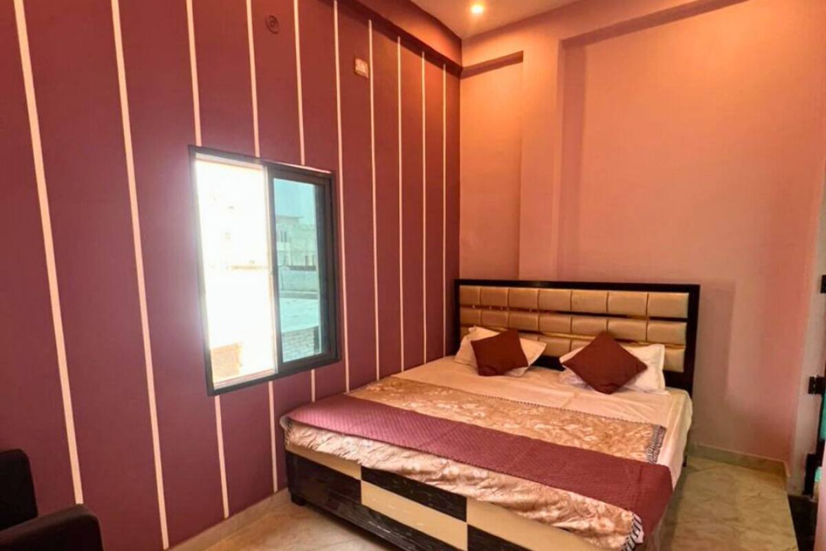 A bedroom with a bed, a ceiling fan, a window, and a door.